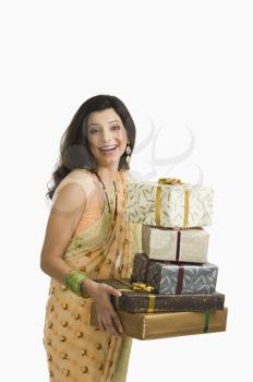 Woman holding Diwali presents and smiling