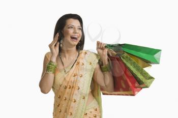 Woman talking on a mobile phone and holding shopping bags