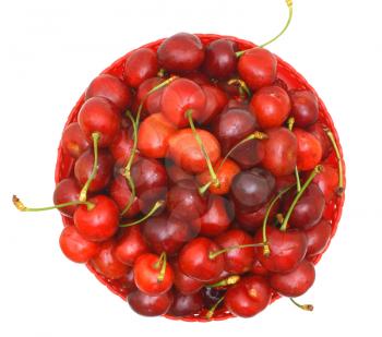 Sweet cherry fruits in a red plate from above on a white background.                    