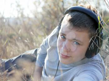 Royalty Free Photo of a Boy Outside Listening to Music