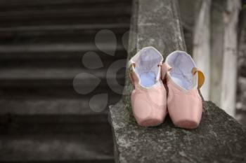 Pink pointe shoes for a classical ballerina, close-up on concrete
