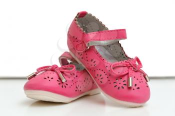 Beautiful pink baby shoes on a white background