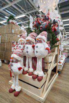 Shelf in the store with the sale of soft toys Snowmen on long legs and gray mice for Christmas decoration or New Year in a store with decor