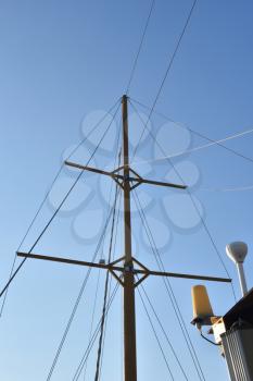 High old mast of the ship against the blue sky