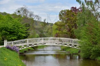 A beautiful white wrought iron bridge over a river in the European city of Baden Baden. Landscape with a bridge over a river