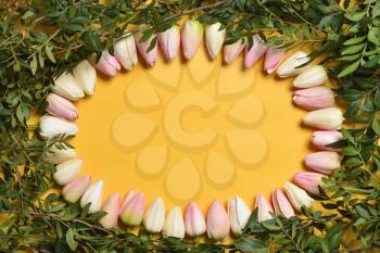 Oval frame of tulip flowers on a yellow background, template with text space. Mothers Day or March 8 holidays concept.