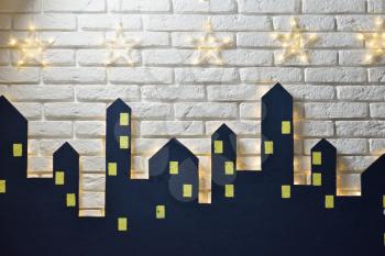 Decorations of the children's room for the New Year or Christmas, the silhouette of the city on a background of a white brick wall, place for text