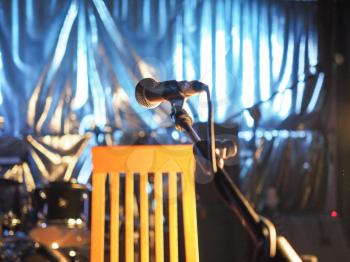 A microphone on an empty stage before a concert - selective focus on the mic with blurred background