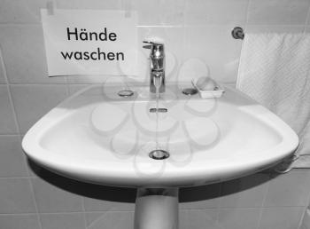 Haende waschen (translation: wash your hands) sign near bathroom basin