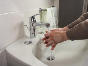 Unrecognisable man carefully washing hands at home for health safety