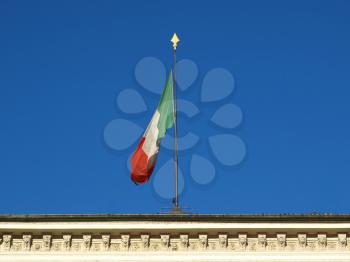 The national Italian flag of Italy (IT) - over blue sky background