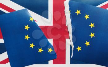 Torn European Union flag over Union Jack United Kingdom flag, symbol of Brexit