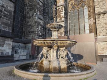 Petrusbrunnen (meaning St Peter fountain) by the Koelner Dom Hohe Domkirche Sankt Petrus (meaning St Peter Cathedral) gothic church in Koeln, Germany