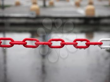 red and white plastic chain with rain drops, selective focus with blurred background