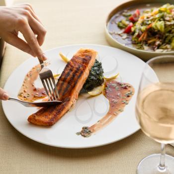 Cutting beautiful salmon meal with lemon and white wine