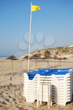 Royalty Free Photo of Locked Beach Chairs and Flag