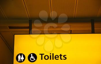 Royalty Free Photo of a Yellow Public Toilet Sign