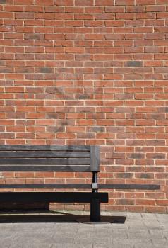 Royalty Free Photo of a Bench Against a Brick Wall