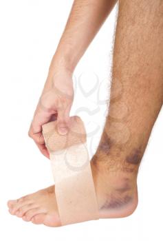 Royalty Free Clipart Image of a Man Bandaging a Sprained Ankle