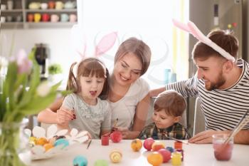 Family painting Easter eggs together at table�