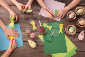 Little children making Easter decorations at table�