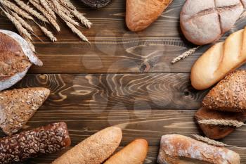 Freshly baked bread products on wooden background, top view�