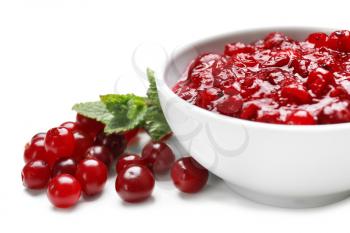 Bowl with tasty cranberry sauce on white background�