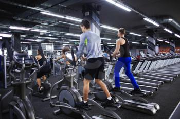 People exercising on training machines in gym�