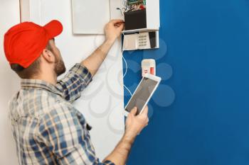 Young electrician installing alarm system�