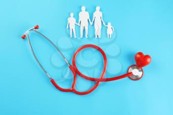 Family figure, red heart and stethoscope on color background. Health care concept�