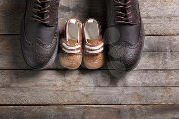 Big and small shoes on wooden background. Father's day�
