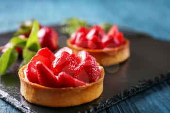 Tasty tartlet with strawberries on table, closeup�