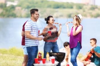Young people having barbecue party on sunny day outdoors�