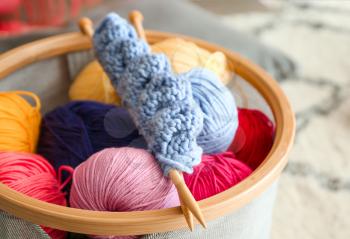 Colorful knitting yarn with needles in basket, closeup�