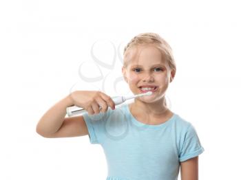 Cute little girl brushing teeth on white background�