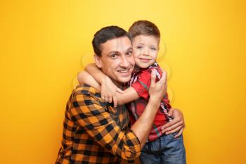 Little boy and his dad on color background�