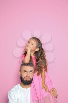 Portrait of father and his little daughter on color background�
