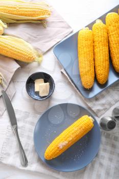 Composition with boiled corncobs on wooden table�