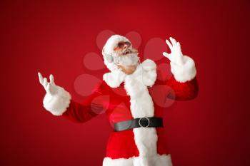 Portrait of cool Santa Claus listening to music on color background�