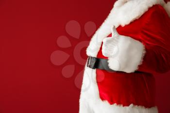 Santa Claus showing thumb-up on color background, closeup�