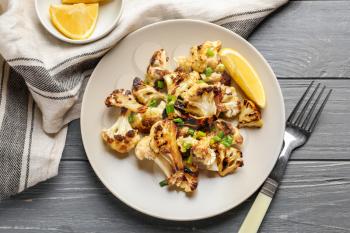 Plate with tasty grilled cauliflower on wooden table�