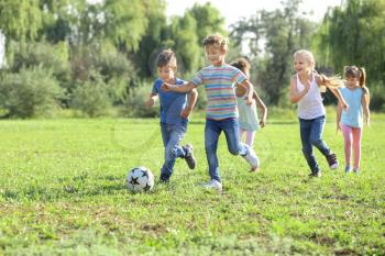 Cute little children playing football outdoors�
