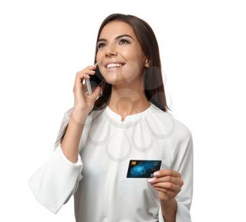 Young woman with credit card talking on mobile phone against white background. Online shopping�