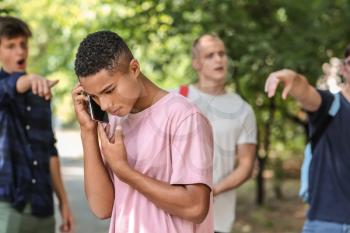 Bullied African-American teenage boy  calling for help outdoors�