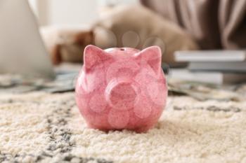 Piggy bank on soft carpet indoors�