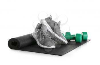 Yoga mat, sport shoes and dumbbells on white background�