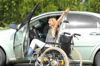 Happy handicapped woman on driver's seat of her car�