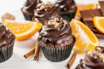 Delicious chocolate cupcake with orange on wooden table�