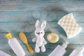 Bunny toy with cosmetics and accessories for baby on wooden table�