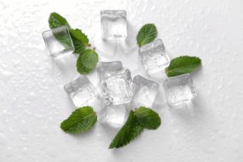 Ice cubes and mint leaves on white background�